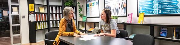 Janelle Andreini sits across from a female student in the Career Center.